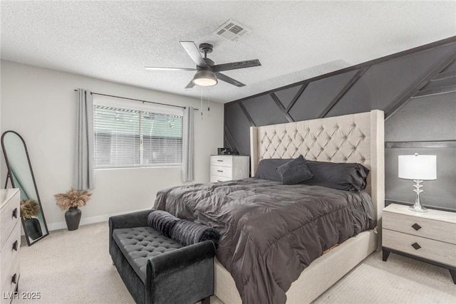 bedroom featuring light colored carpet, a textured ceiling, visible vents, a ceiling fan, and baseboards