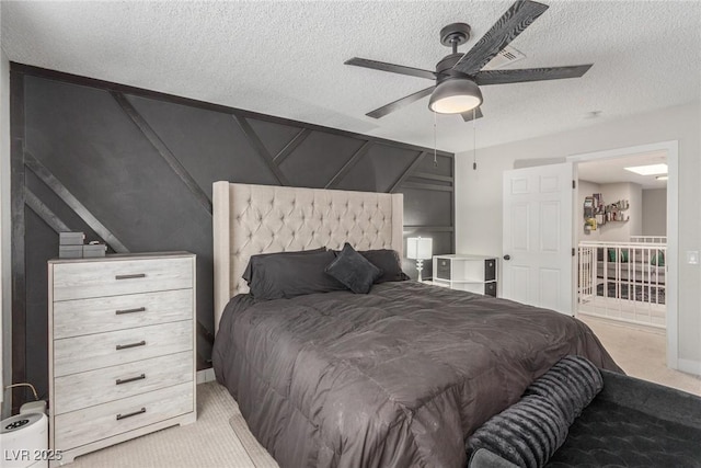 bedroom featuring light colored carpet, a textured ceiling, and ceiling fan