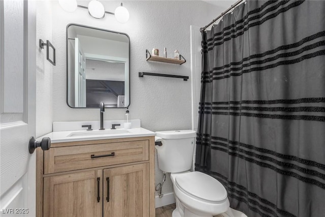 full bath featuring toilet, curtained shower, vanity, and a textured wall