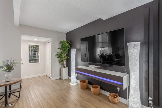 bathroom with baseboards, a textured ceiling, and wood finished floors