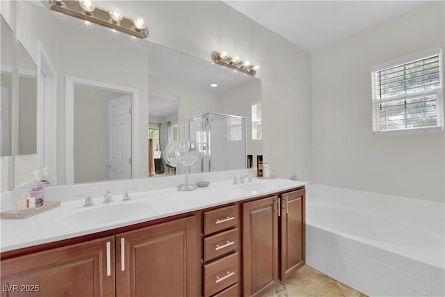 bathroom featuring a wealth of natural light, a bath, and a sink