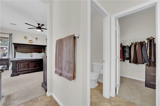 bathroom featuring toilet, visible vents, baseboards, and ceiling fan