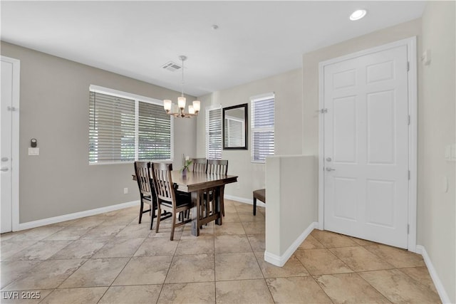 dining area with light tile patterned floors, a healthy amount of sunlight, an inviting chandelier, and visible vents
