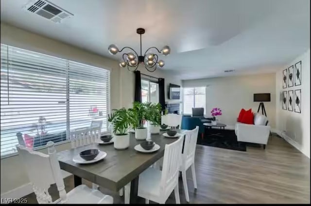 6736 Quinella Dr, Las Vegas, NV 89103 - dining room with visible vents, wood finished floors, baseboards, and a notable chandelier