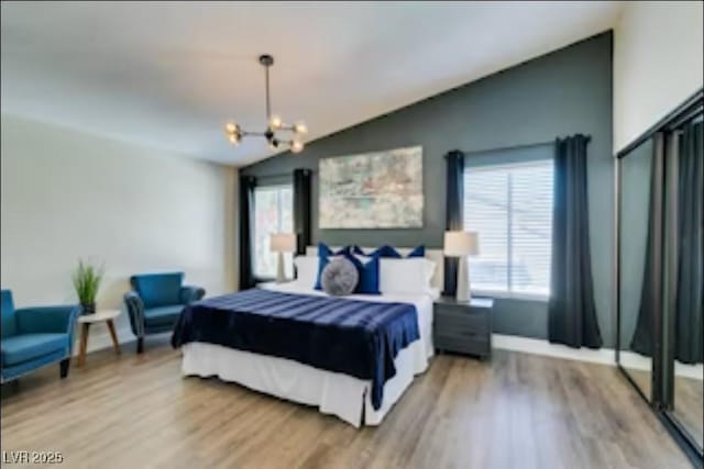 6736 Quinella Dr, Las Vegas, NV 89103 - bedroom with an inviting chandelier, lofted ceiling, light wood-type flooring, and multiple windows