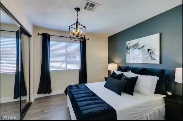 6736 Quinella Dr, Las Vegas, NV 89103 - bedroom with a chandelier, multiple windows, visible vents, and wood finished floors