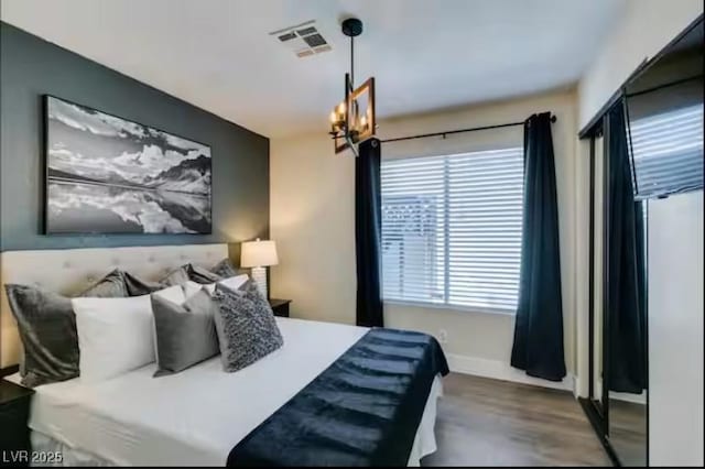 6736 Quinella Dr, Las Vegas, NV 89103 - bedroom featuring baseboards, visible vents, and wood finished floors
