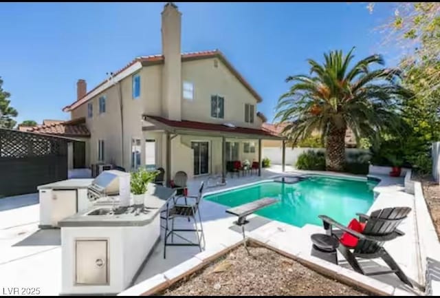 6736 Quinella Dr, Las Vegas, NV 89103 - back of house with a patio, stucco siding, a fenced backyard, a chimney, and an outdoor kitchen