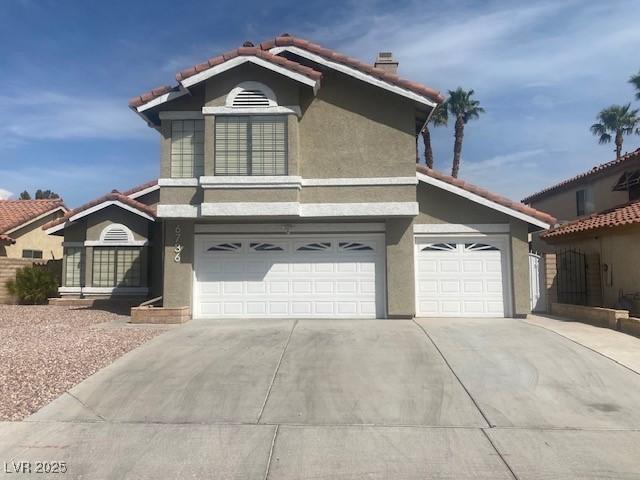 6736 Quinella Dr, Las Vegas, NV 89103 - traditional-style house with a garage, a tiled roof, stucco siding, a chimney, and driveway