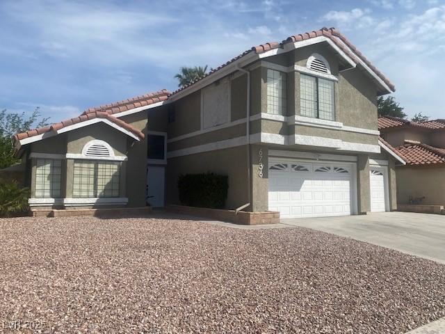 6736 Quinella Dr, Las Vegas, NV 89103 - view of front facade featuring stucco siding, an attached garage, a tiled roof, and driveway