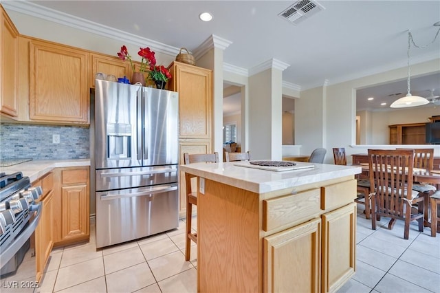 1613 Williamsport St, Henderson, NV 89052 - kitchen featuring appliances with stainless steel finishes, light tile patterned floors, light brown cabinetry, a kitchen island, and backsplash