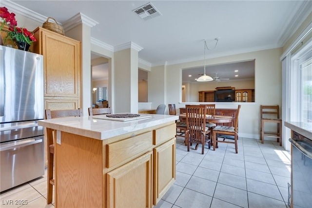 1613 Williamsport St, Henderson, NV 89052 - kitchen featuring appliances with stainless steel finishes, light brown cabinetry, ornamental molding, light tile patterned flooring, and a center island