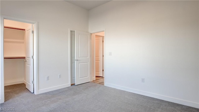 1157 Blossom Point St, Las Vegas, NV 89135 - unfurnished bedroom featuring a walk in closet, carpet flooring, and baseboards