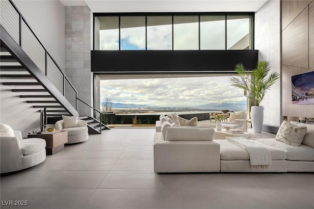 12 Chisel Crest Ct, Henderson, NV 89012 - living room with tile patterned flooring, a towering ceiling, stairs, and expansive windows