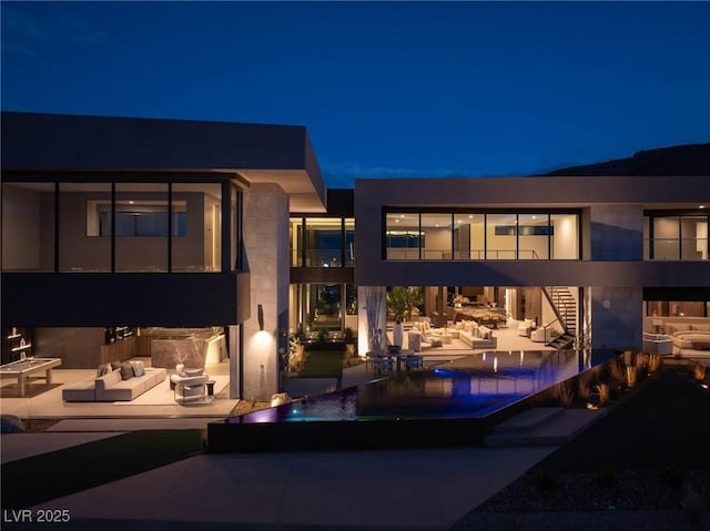 12 Chisel Crest Ct, Henderson, NV 89012 - back of house at twilight with outdoor lounge area, a patio, stairway, and a balcony