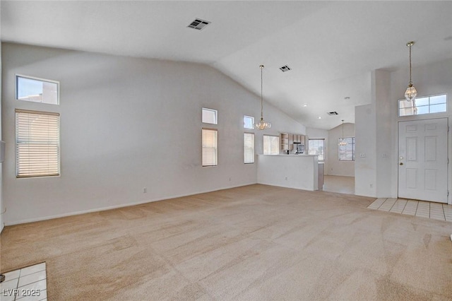 unfurnished living room featuring a chandelier, light carpet, high vaulted ceiling, and visible vents