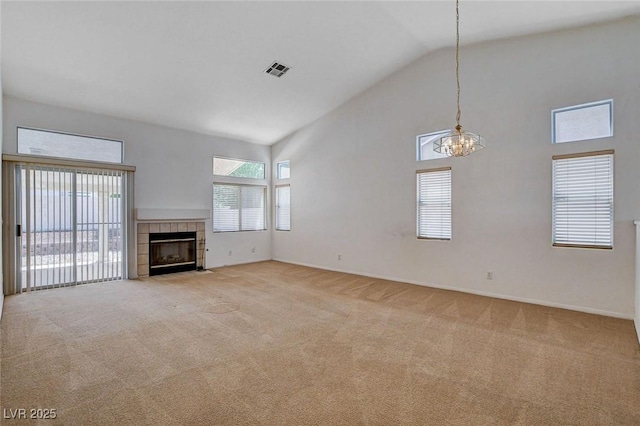 unfurnished living room with a notable chandelier, visible vents, a healthy amount of sunlight, and light carpet