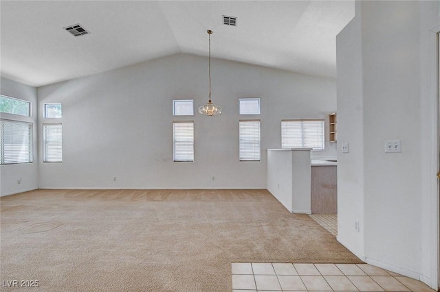 interior space featuring a chandelier, visible vents, light colored carpet, and vaulted ceiling