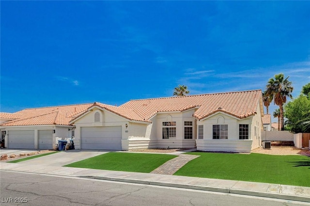 mediterranean / spanish home featuring a tile roof, an attached garage, and stucco siding
