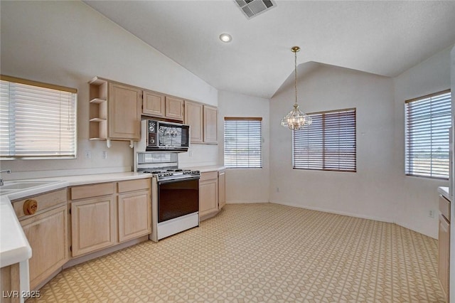 kitchen featuring light brown cabinetry, visible vents, a sink, black microwave, and range with gas cooktop