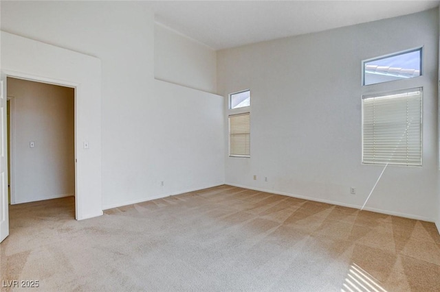 spare room featuring carpet flooring and baseboards