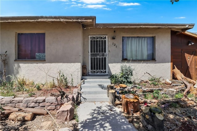 view of exterior entry with stucco siding