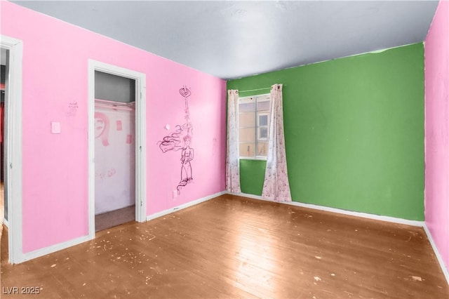 unfurnished bedroom featuring baseboards and wood finished floors