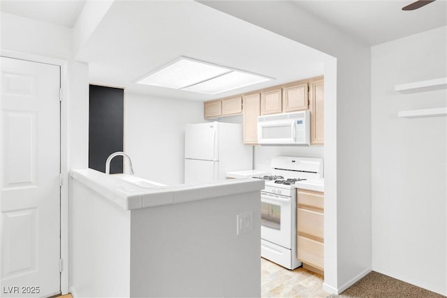 1900 Mountain Hills Ct Unit 203, Las Vegas, NV 89128 - kitchen with light brown cabinetry, white appliances, a sink, a peninsula, and tile counters