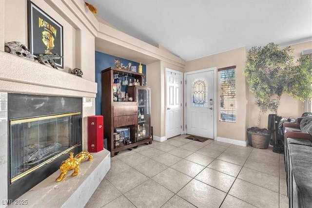 10113 Walhalla Plateau Ct, Las Vegas, NV 89148 - tiled entryway with vaulted ceiling, a glass covered fireplace, and baseboards