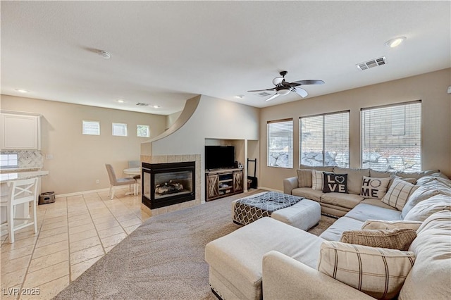 living area with a ceiling fan, baseboards, recessed lighting, light tile patterned floors, and a fireplace