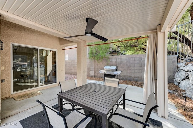 view of patio with outdoor dining space, fence, ceiling fan, and grilling area