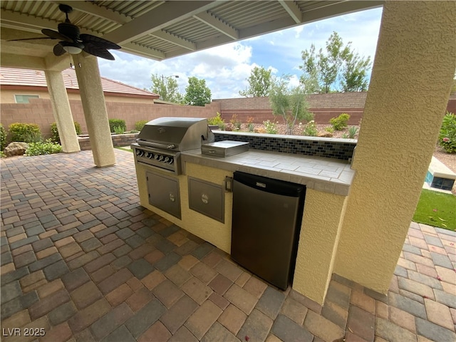 10331 Northern Hills Ave, Las Vegas, NV 89166 - view of patio featuring a fenced backyard, ceiling fan, area for grilling, and exterior kitchen