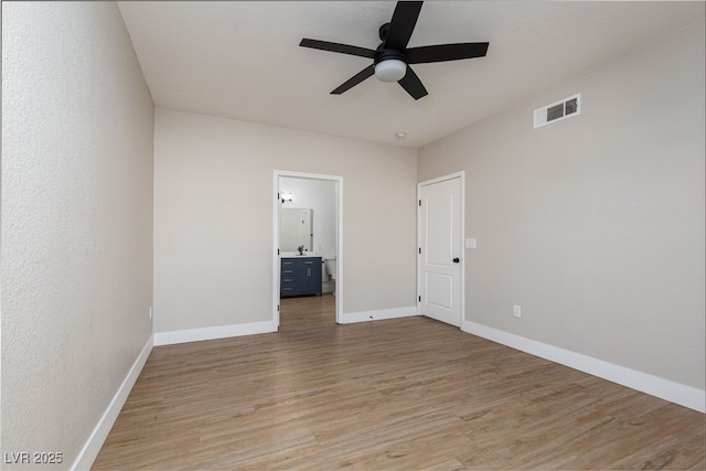 unfurnished room with light wood-type flooring, a ceiling fan, and baseboards