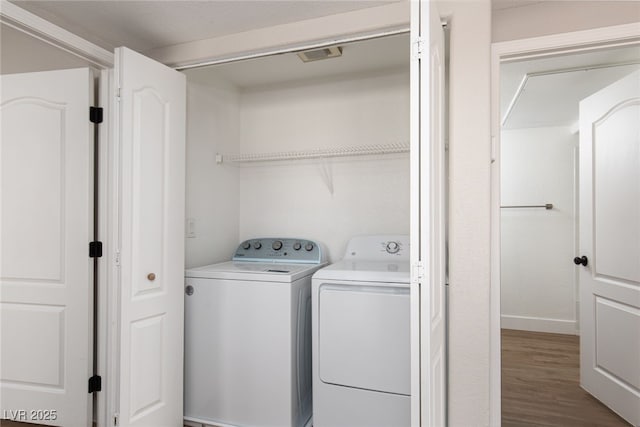 laundry area with washer and clothes dryer and wood finished floors