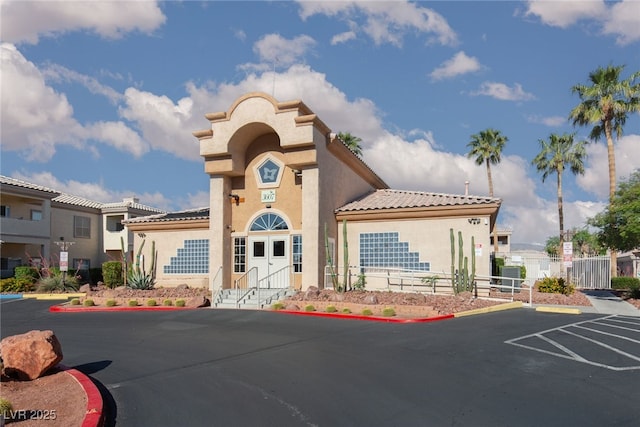view of property with uncovered parking and fence