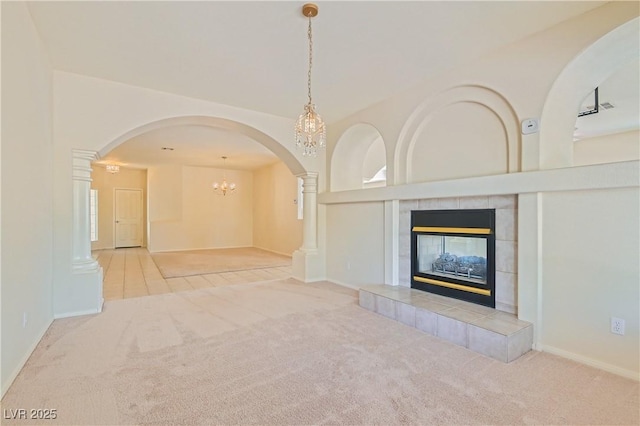 427 Rhythm St, Henderson, NV 89074 - unfurnished living room with an inviting chandelier, carpet, arched walkways, and a tiled fireplace