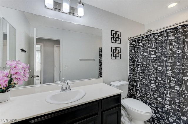 full bath featuring toilet, vanity, and curtained shower