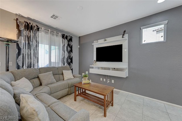 living area with baseboards, light tile patterned floors, and visible vents