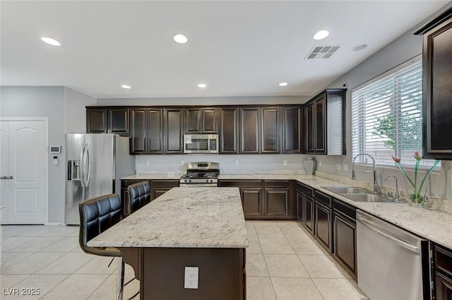 kitchen featuring light tile patterned floors, stainless steel appliances, visible vents, and a sink