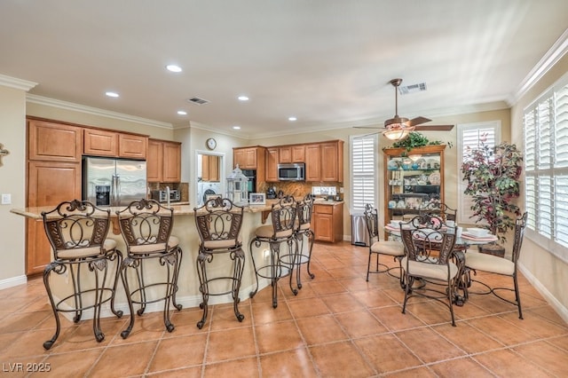 10314 Premia Pl, Las Vegas, NV 89135 - kitchen featuring tasteful backsplash, stainless steel appliances, brown cabinets, and visible vents