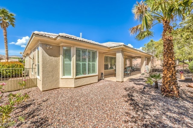 10314 Premia Pl, Las Vegas, NV 89135 - rear view of property featuring stucco siding, a tile roof, fence, and a patio