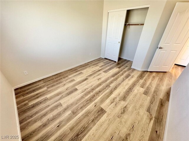 3919 Lilac Haze St, Las Vegas, NV 89147 - unfurnished bedroom with a closet, wood finished floors, and baseboards