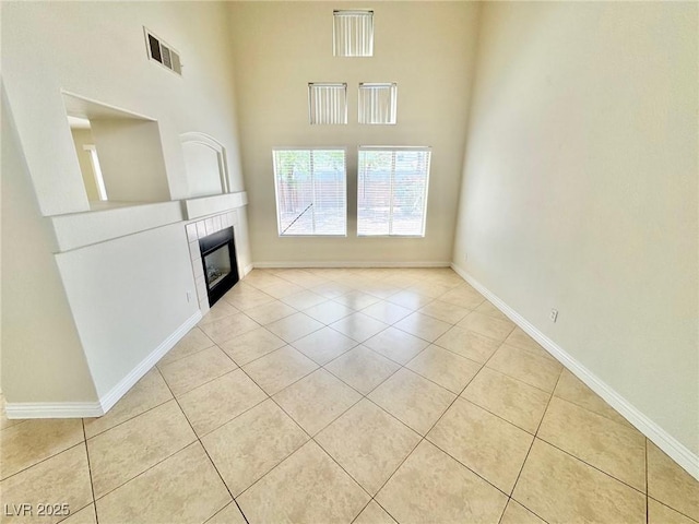 3919 Lilac Haze St, Las Vegas, NV 89147 - unfurnished living room featuring light tile patterned floors, baseboards, a fireplace, and visible vents