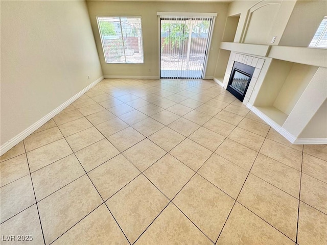 3919 Lilac Haze St, Las Vegas, NV 89147 - unfurnished living room with baseboards, a tile fireplace, and light tile patterned floors