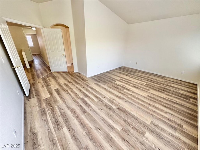 3919 Lilac Haze St, Las Vegas, NV 89147 - unfurnished room with arched walkways, lofted ceiling, light wood-type flooring, and baseboards