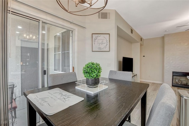 dining space with a chandelier, visible vents, and wood finished floors