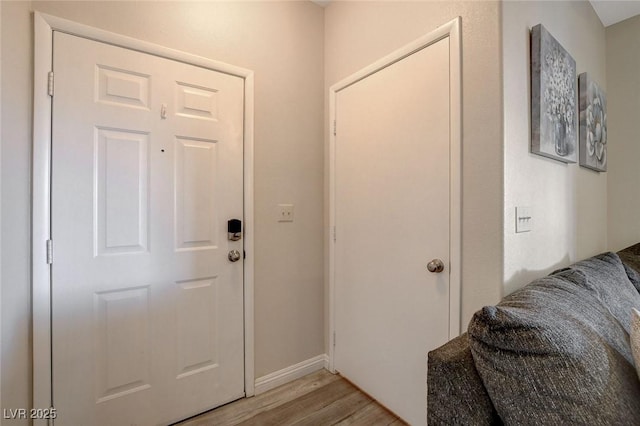 foyer featuring baseboards and light wood-type flooring