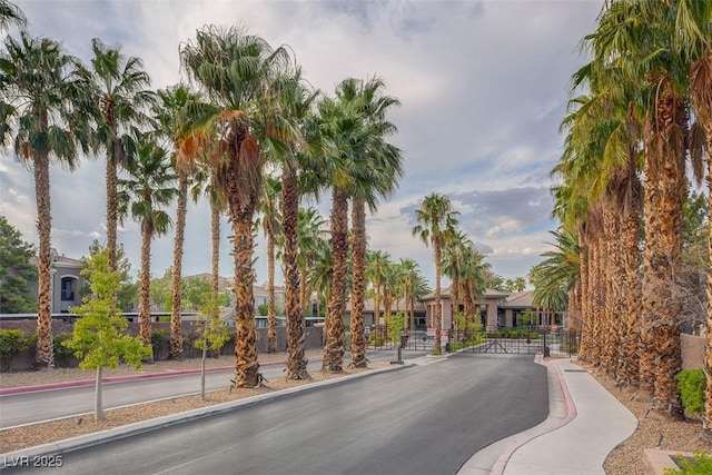 view of road with a gated entry and curbs