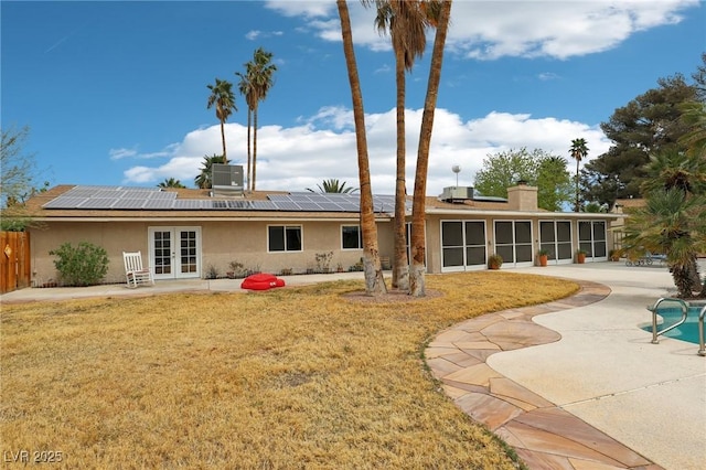 3155 Duneville St, Las Vegas, NV 89146 - rear view of property with roof mounted solar panels, stucco siding, french doors, and a lawn