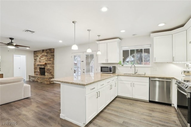 3155 Duneville St, Las Vegas, NV 89146 - kitchen with visible vents, a sink, white cabinetry, a peninsula, and appliances with stainless steel finishes